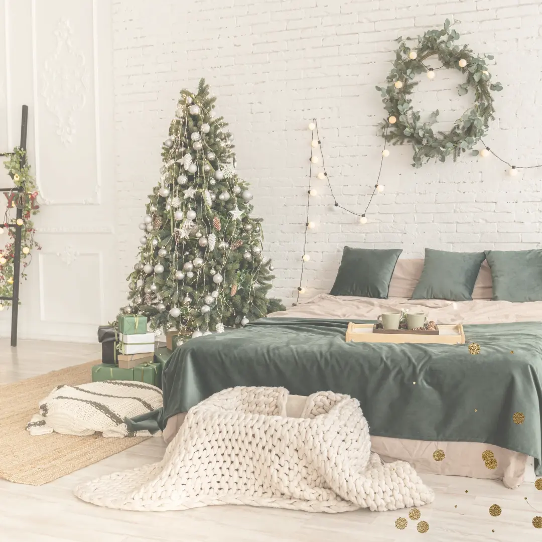 Zu sehen ist ein Bett neben dem ein Weihnachtsbaum steht. Davor steht eine Wiege